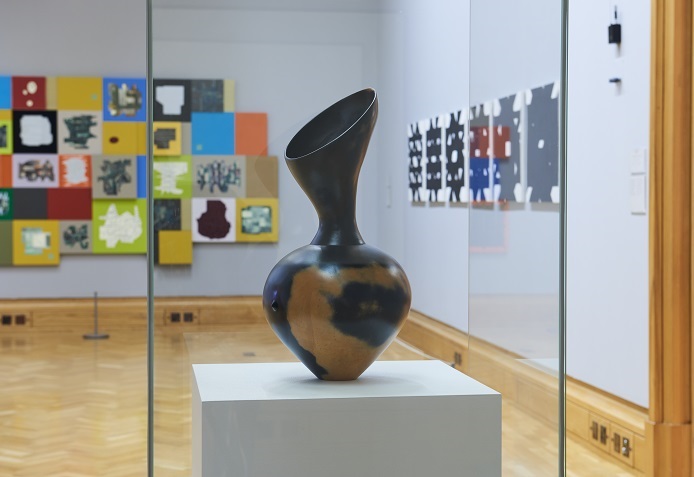 A black and brown, curved vase