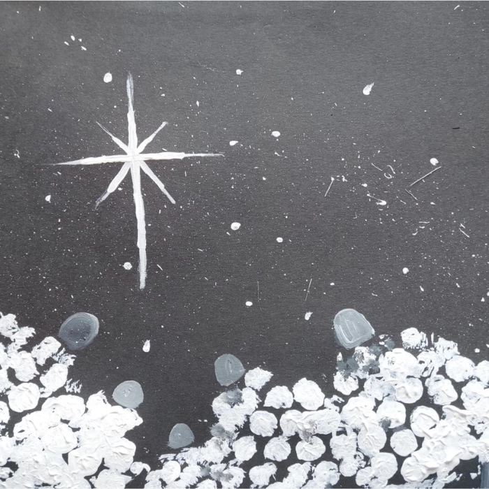 A child's painting of sheep on black paper, made by printing white paint with bubblewrap 