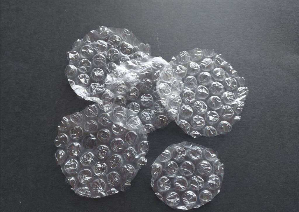 A photo of circular pieces of bubblewrap on a dark background