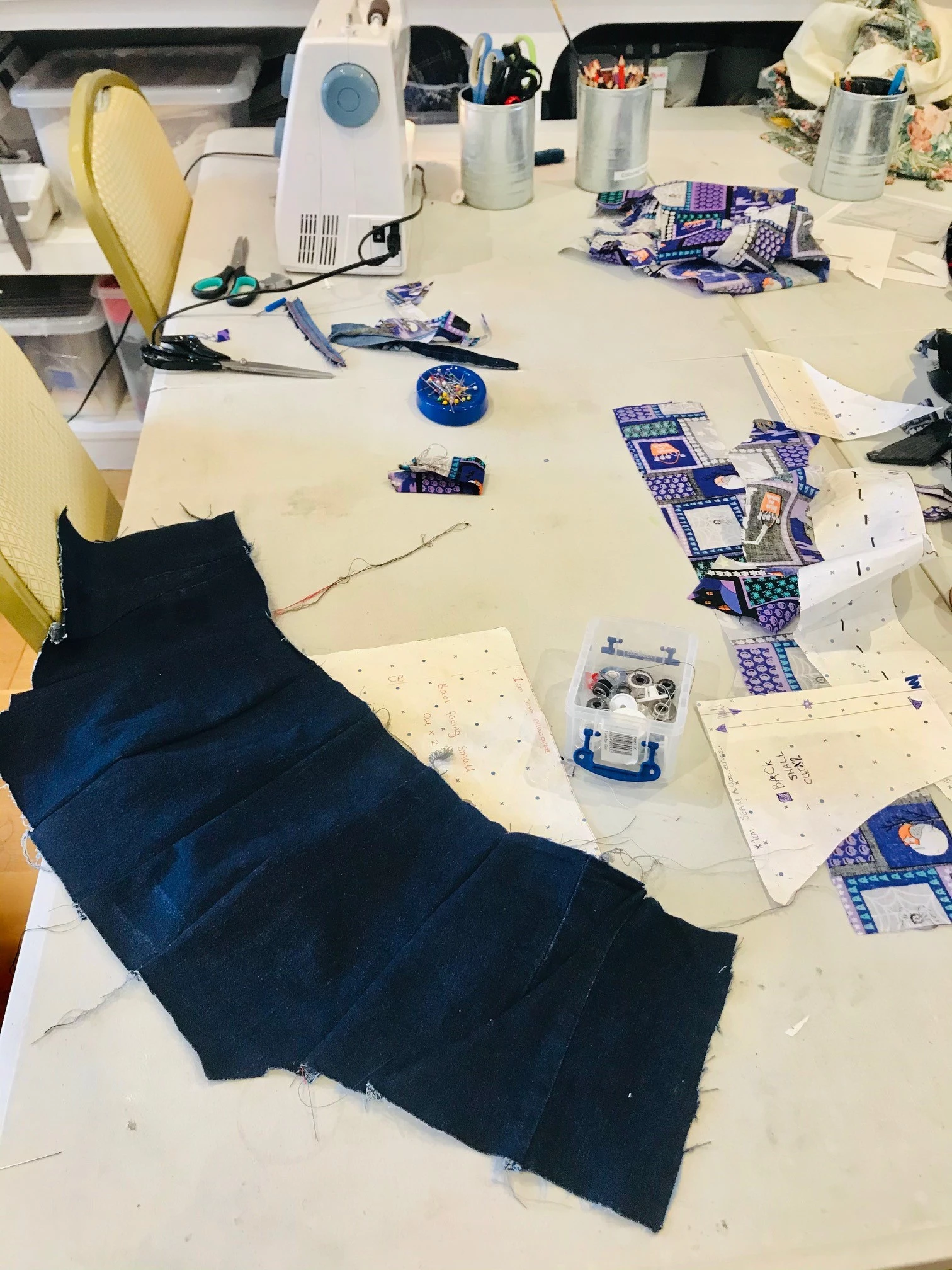 Photograph of fabric on table with sewing machine and equipment