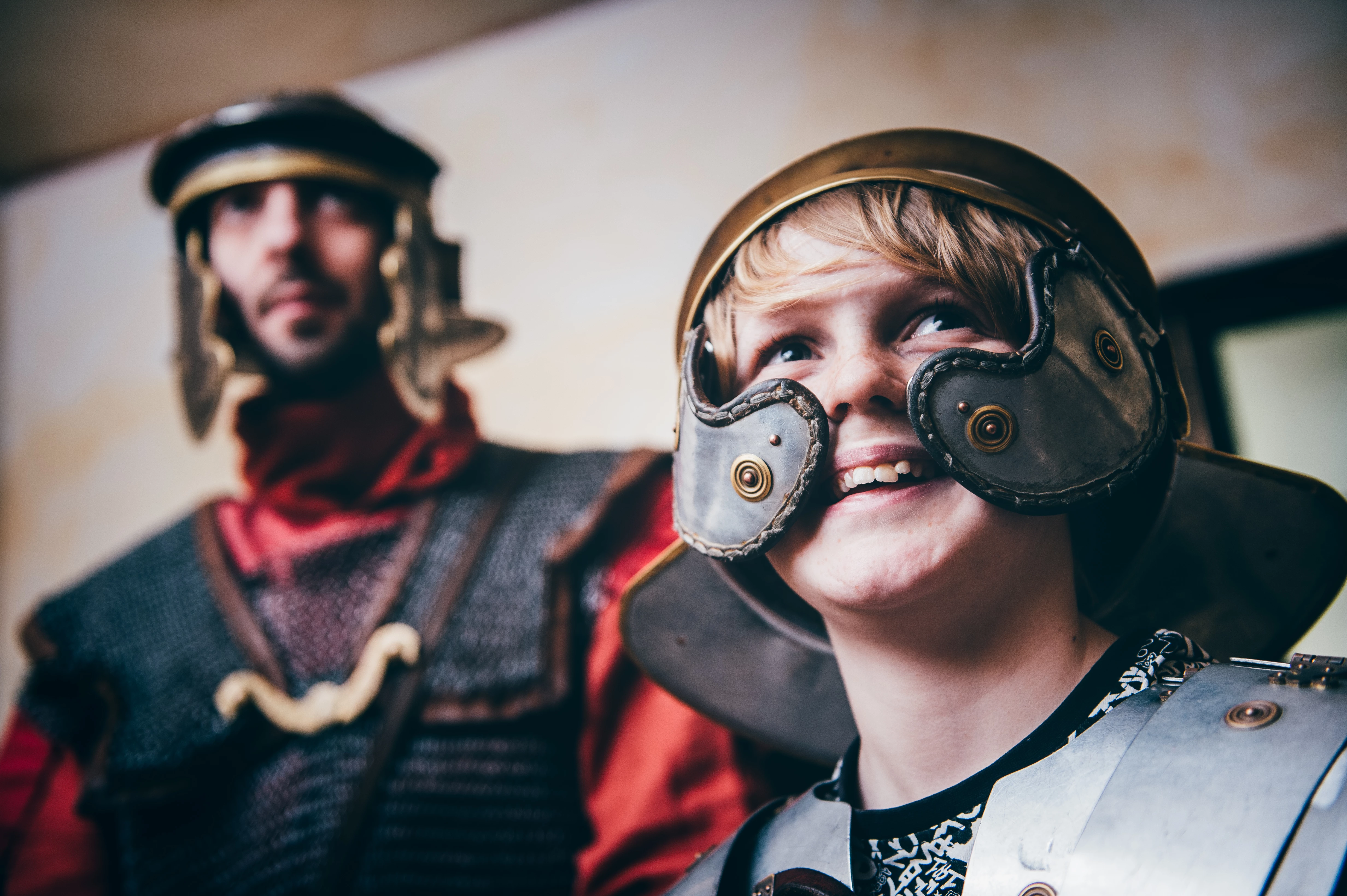 Children dressed in Roman armour stood behind a shield.