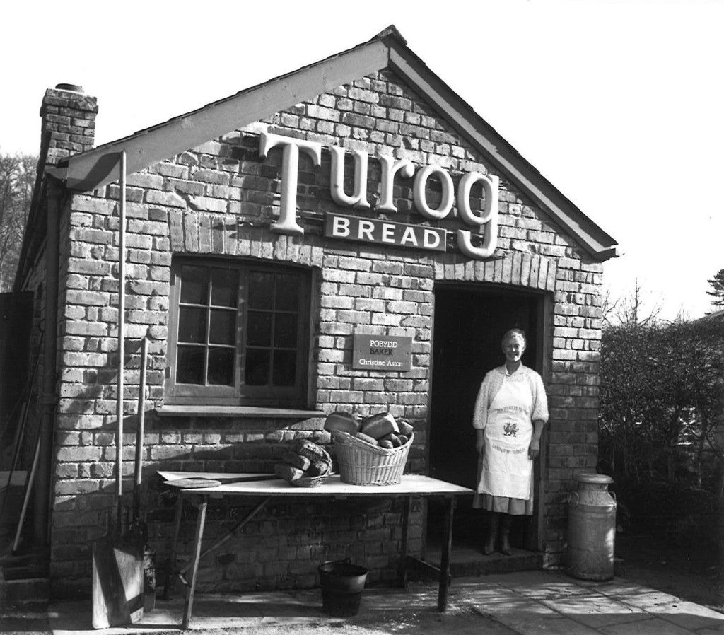 A black and white photo of the Derwen Bakehouse building, with the miller standing at the door