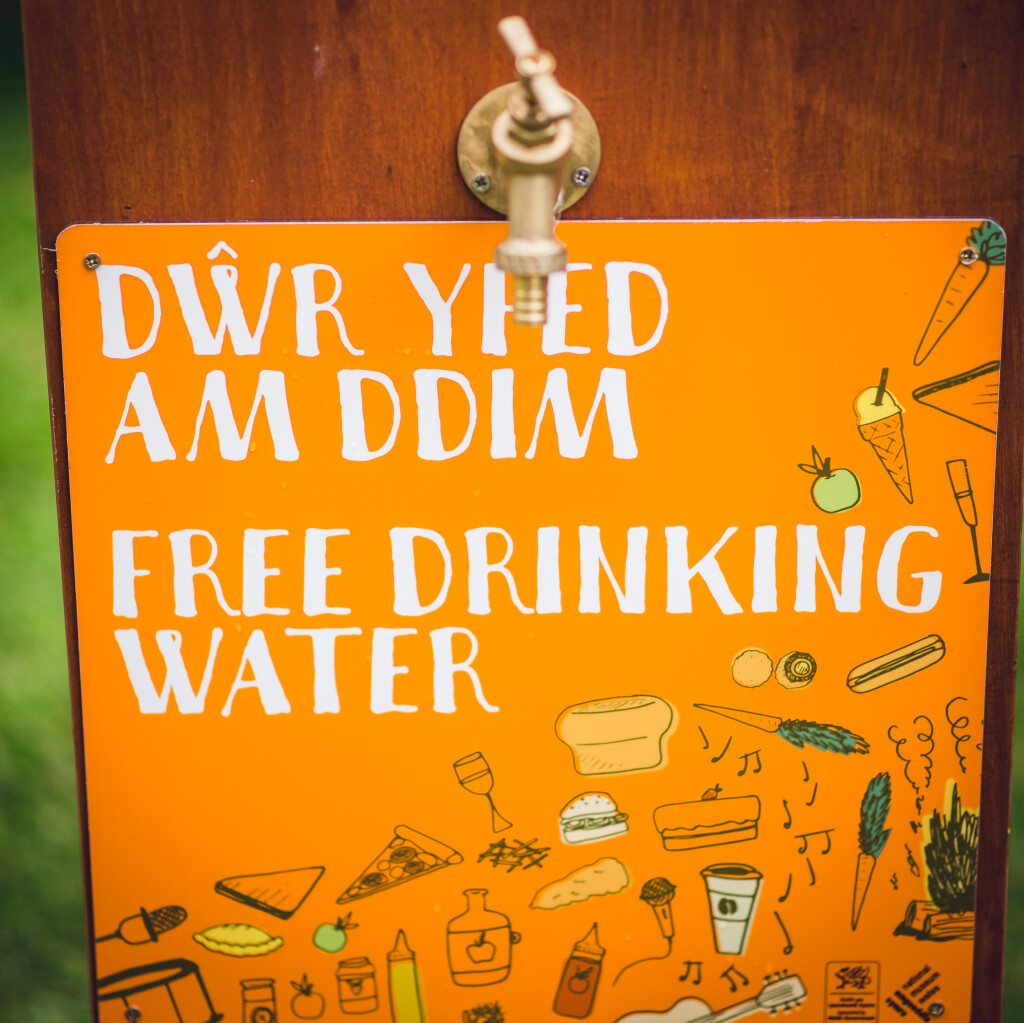 Orange sign that reads 'Dwr Yfed am ddim' 'Free drinking water'