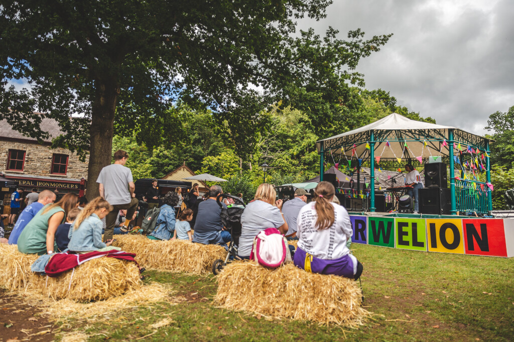 Visitors sitting on straw bales on Gwalia Green during the food festival 