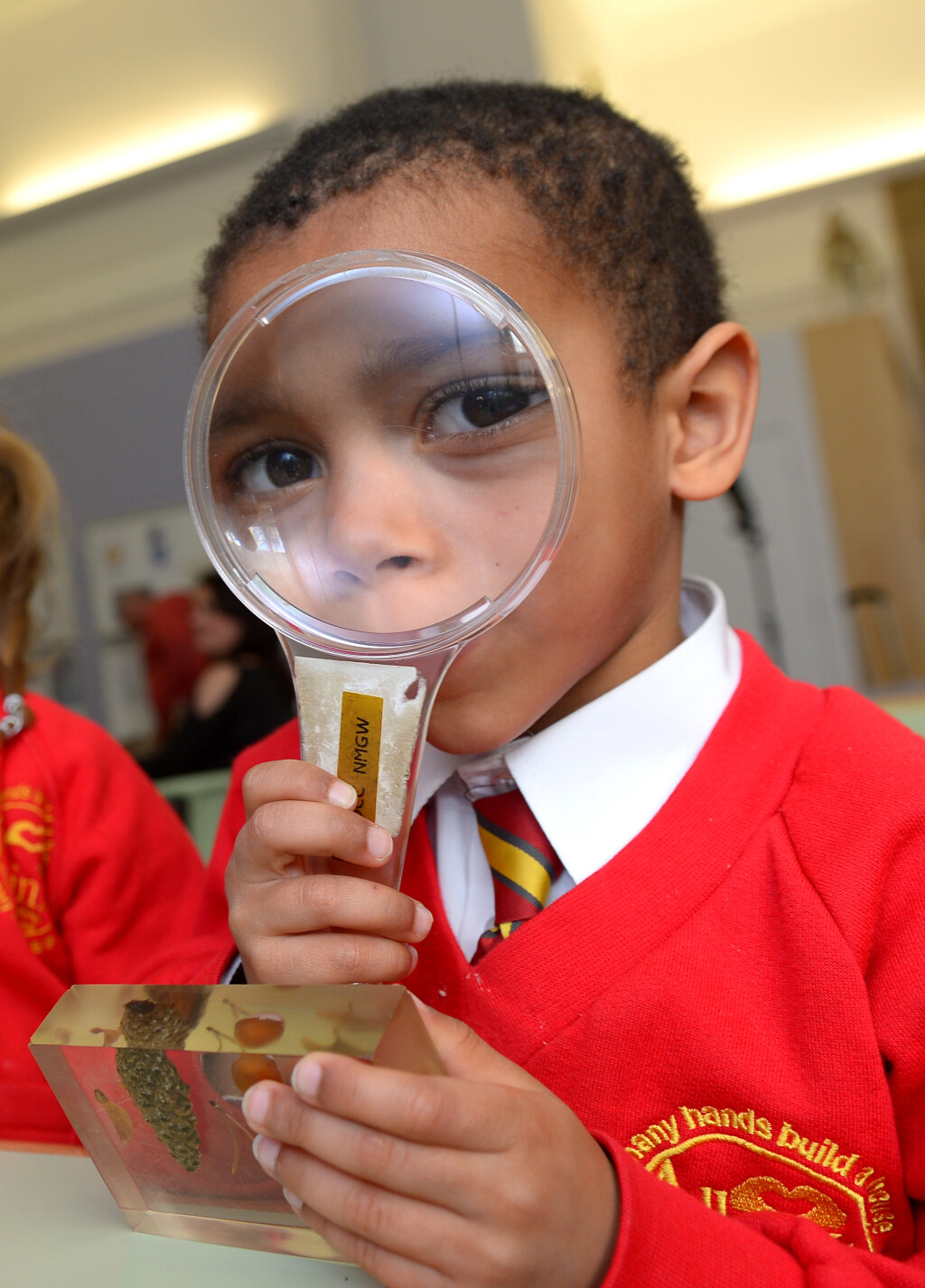 Photo of a child looking through a magnifying glass