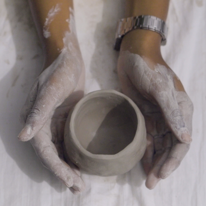 A still from Gesiye's film, showing a person making a cup from clay