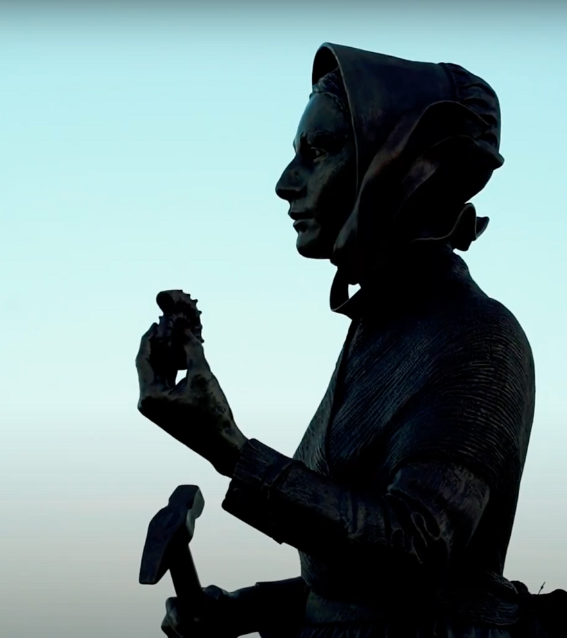 Silhouette of a statue of a woman in 19th-century clothing