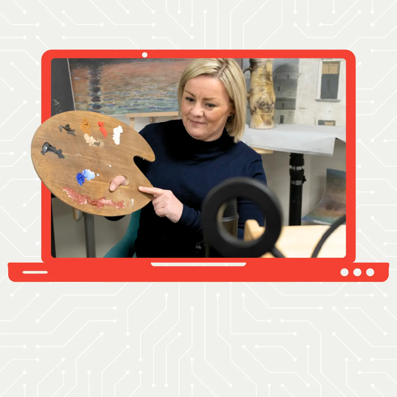 Woman with blonde hair holding a paint palette in front of a camera