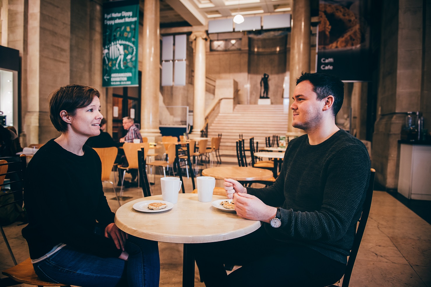 Two people enjoying a coffee and a cake in the museum's cafe