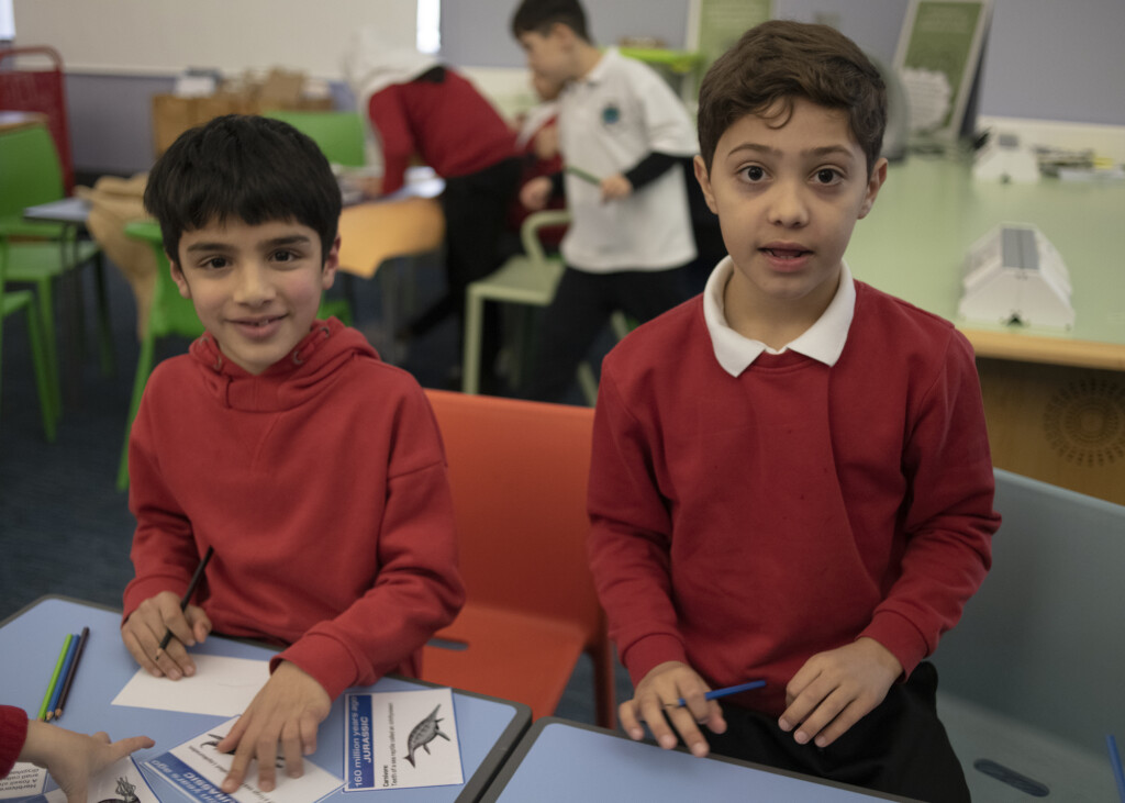 A photo of two boys drawing in an education room in the museum