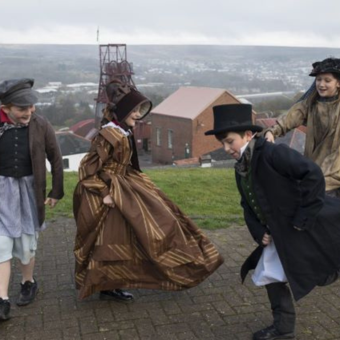 Children playing in Victorian costume above Big Pit.