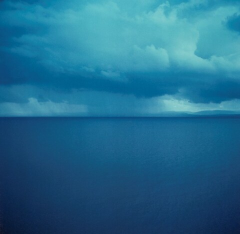 Blue image of sea and sky, horizon line in the centre