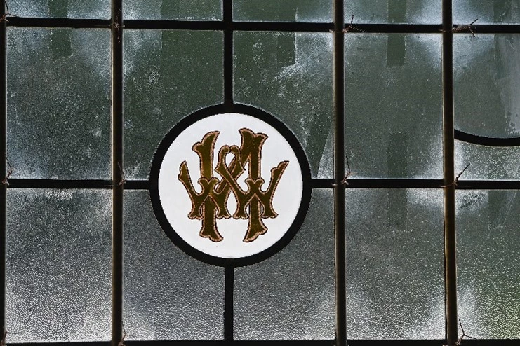 Window pane with a logo incorporating a big letter 'N' with two smaller 'W's behind. They represent William Walter Nell.