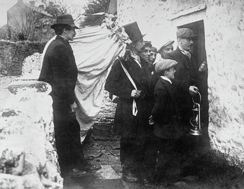 7 people are stood in a doorway with The Mari Lwyd