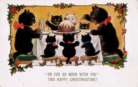 Old christmas card showing a family of cats sat around a table tucking into a christmas pudding, with the words Oh for an hour with you, this Happy Christmastide 
