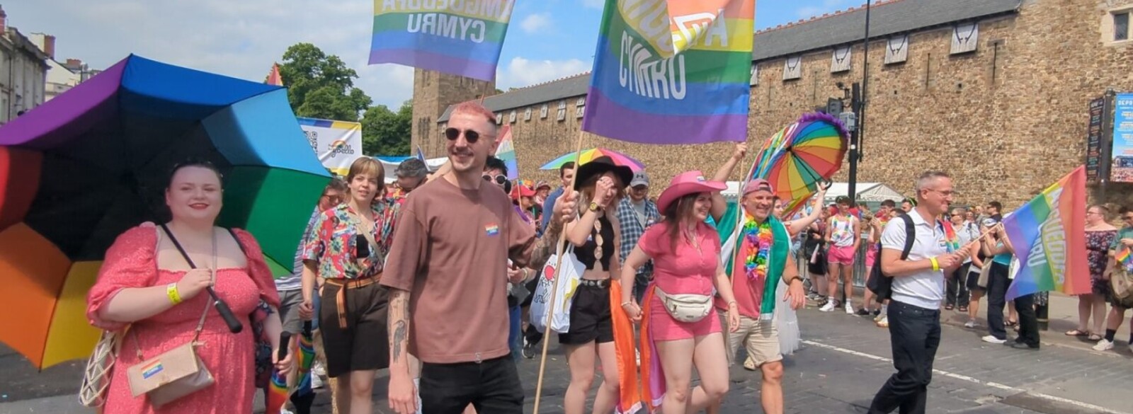 A group of people walking as part of a Pride parade.