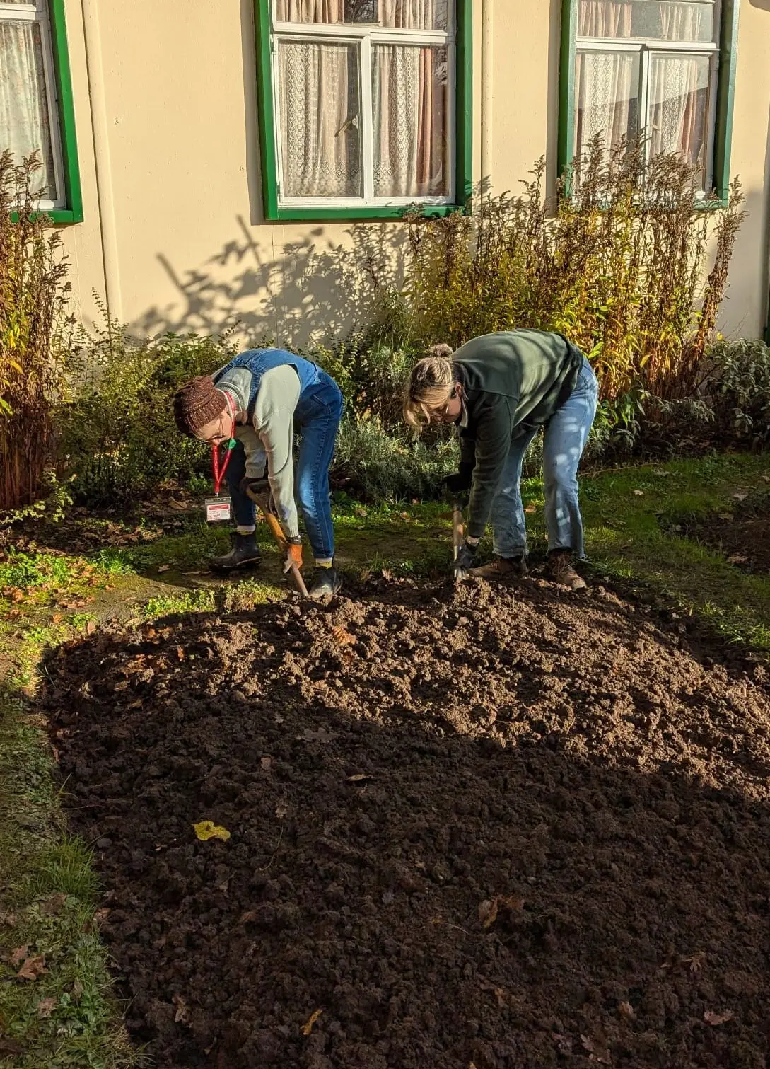 Two gardeners digging over the prefab garden 