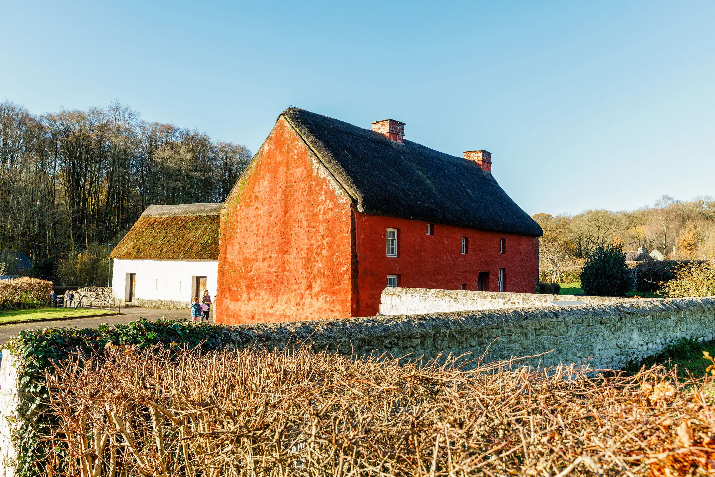 Kennixton - a red farmhouse with a thatched roof in the sunshine 