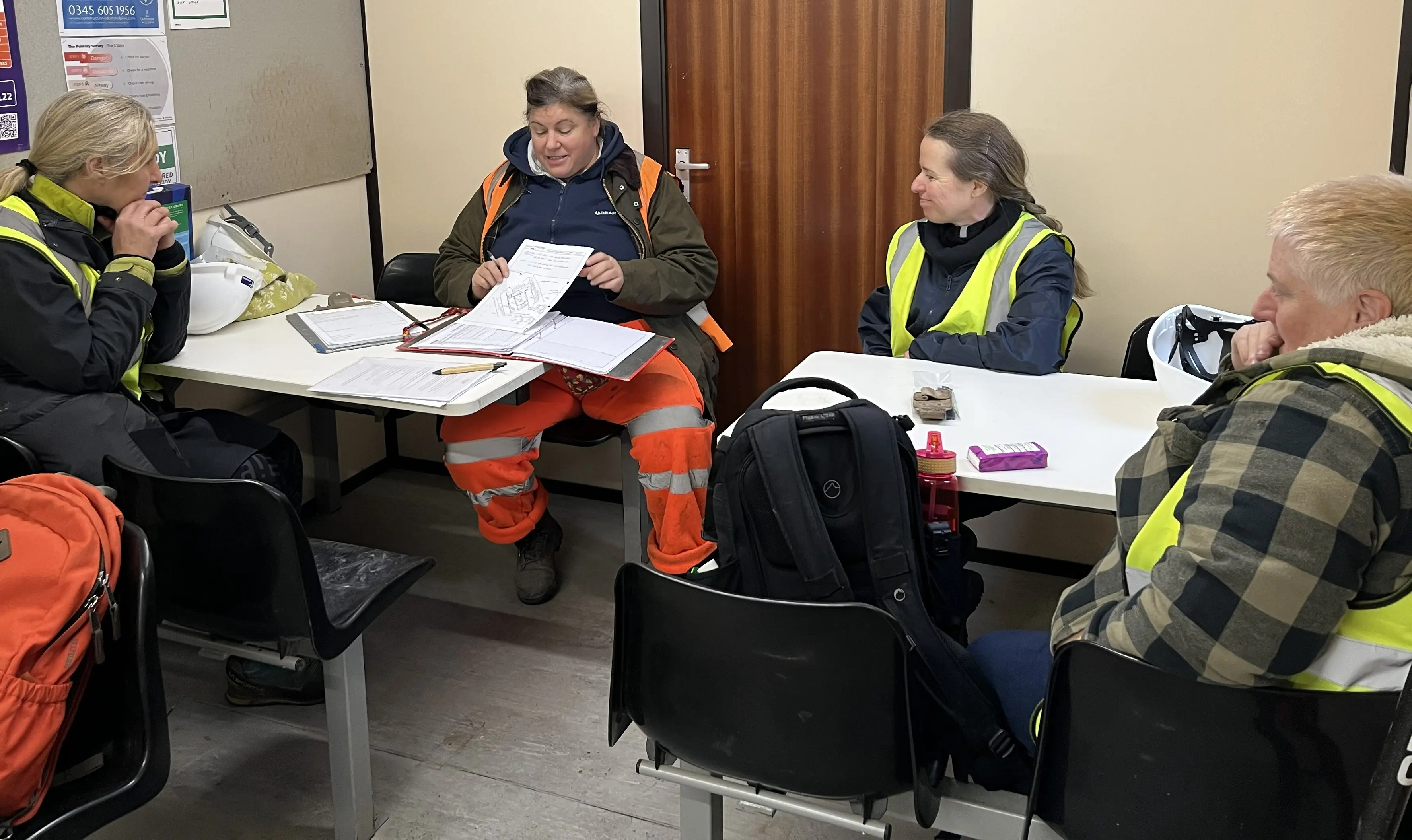 Volunteers sitting at table with Archaeologist.