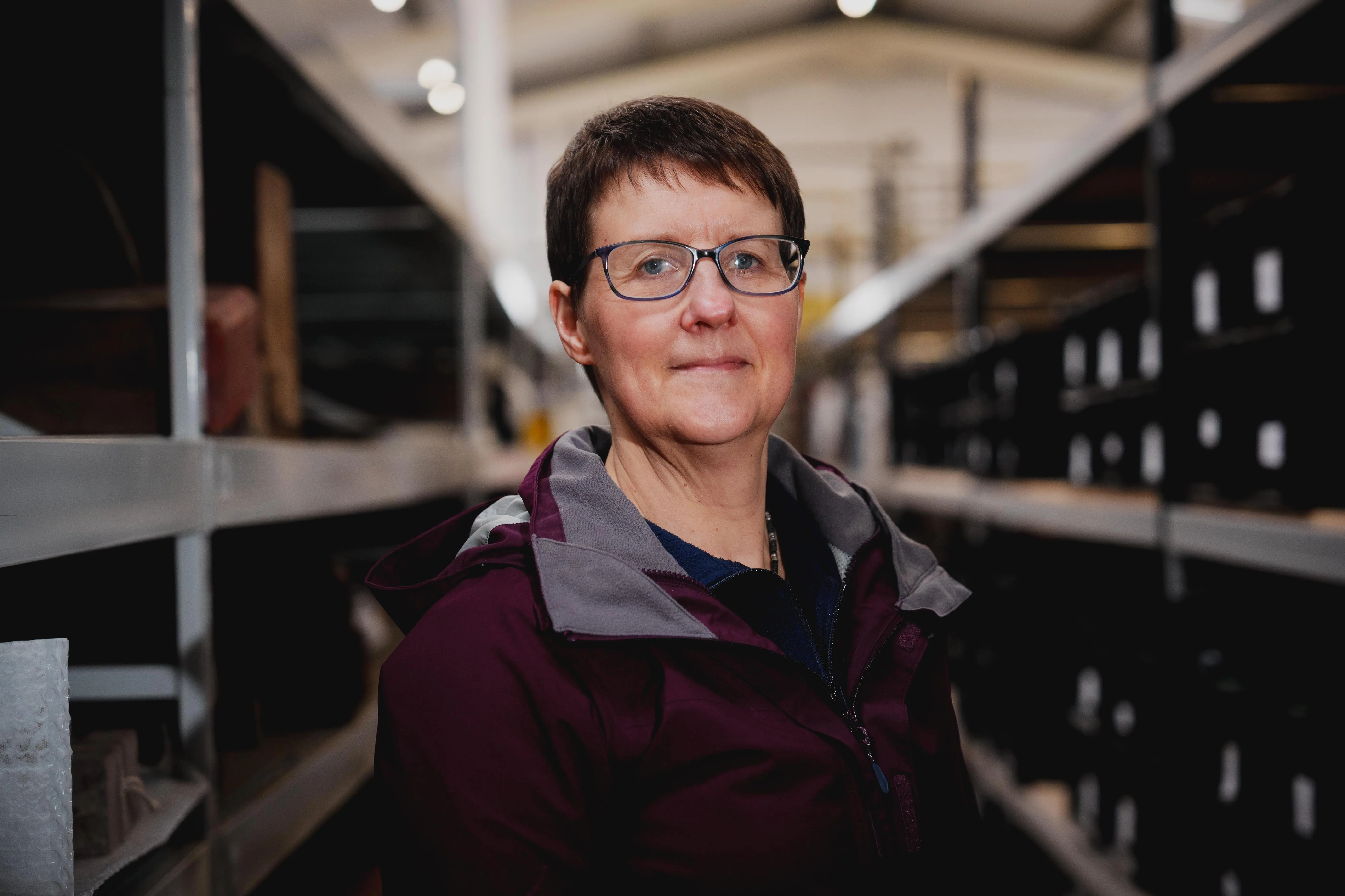 A woman standing in the centre of shelves