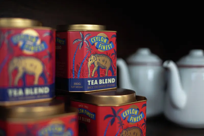 Several square red tea tins with gold lids, featuring an elephant illustration and the brand name Ceylon Finest.