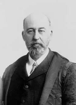  A black and white image of William Evans Hoyle, he is a balding man with a beard, he is wearing a suit with a white shirt with what seems to be an overcoat over the top