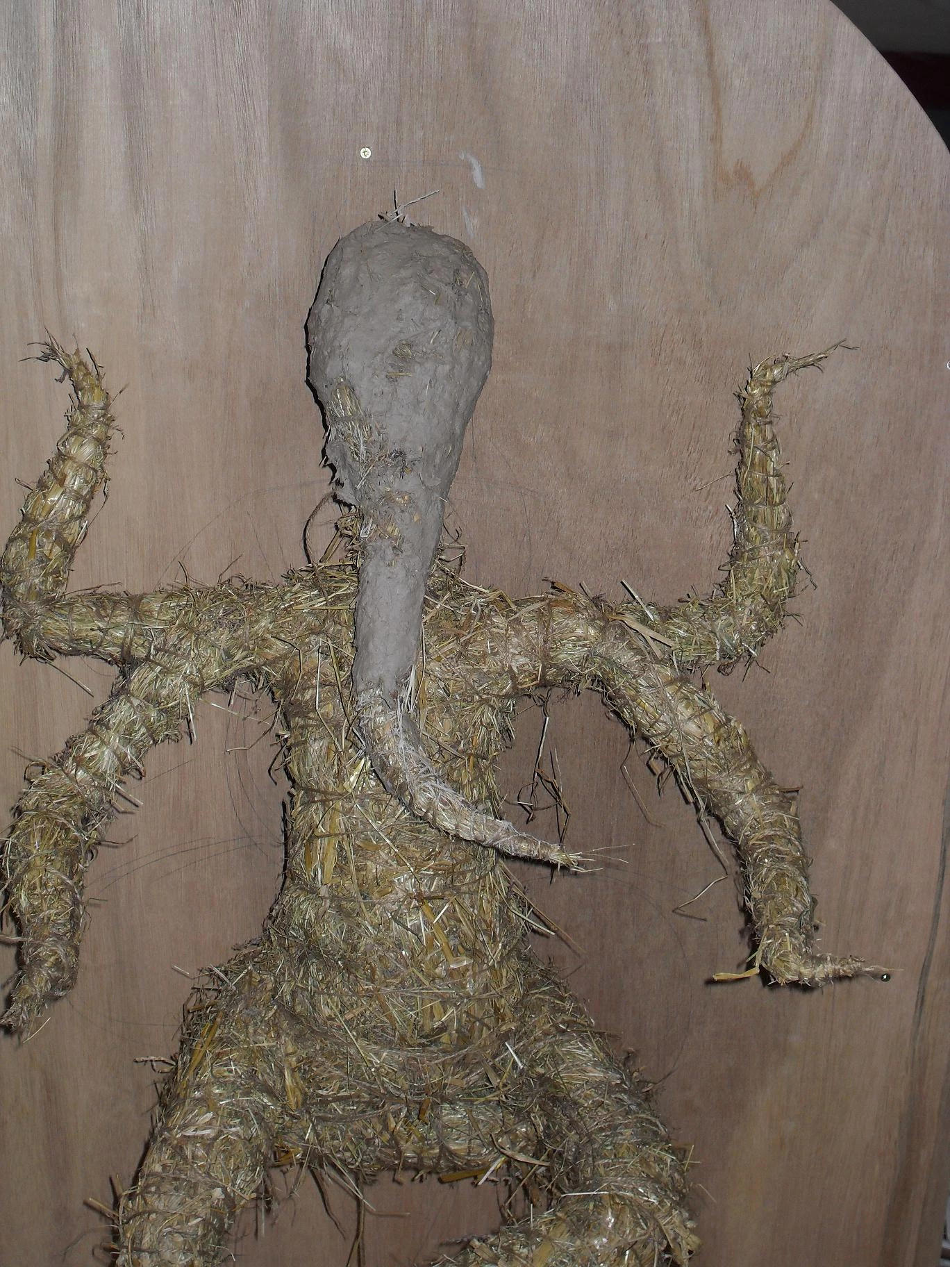 Placing a mixture of clay and paper on to the straw to form Ganesha's head