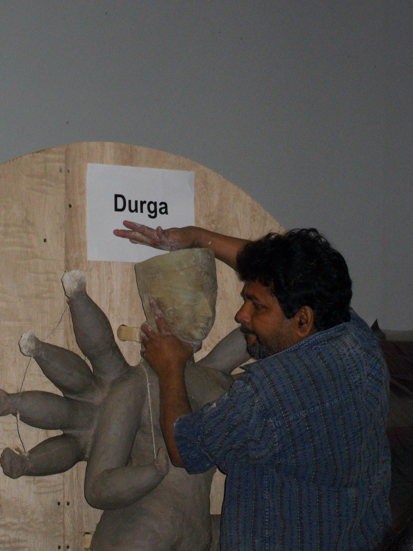 Placing a mask, already made by the artists, on the Goddess Durga's face