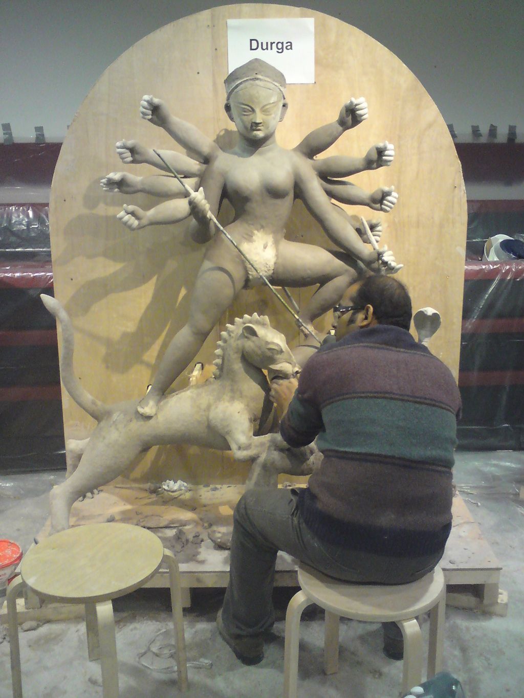 The artist Dibyendu Dey shaping the Goddess Durga, her lion and her foe, the buffalo demon 