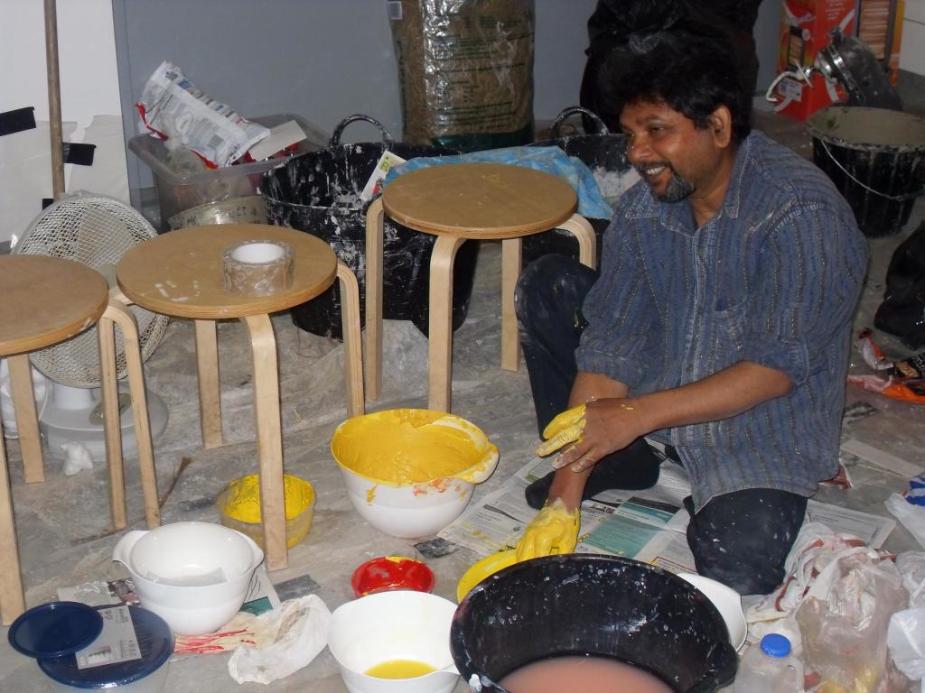 The artist Purnendu Dey mixing the natural powdered pigments with water